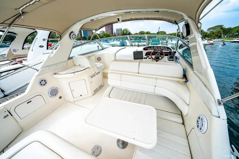 Slide: The Image of 1998 Sea Ray 330 Sundancer boat interior with seating, table, and steering wheel. - 19
