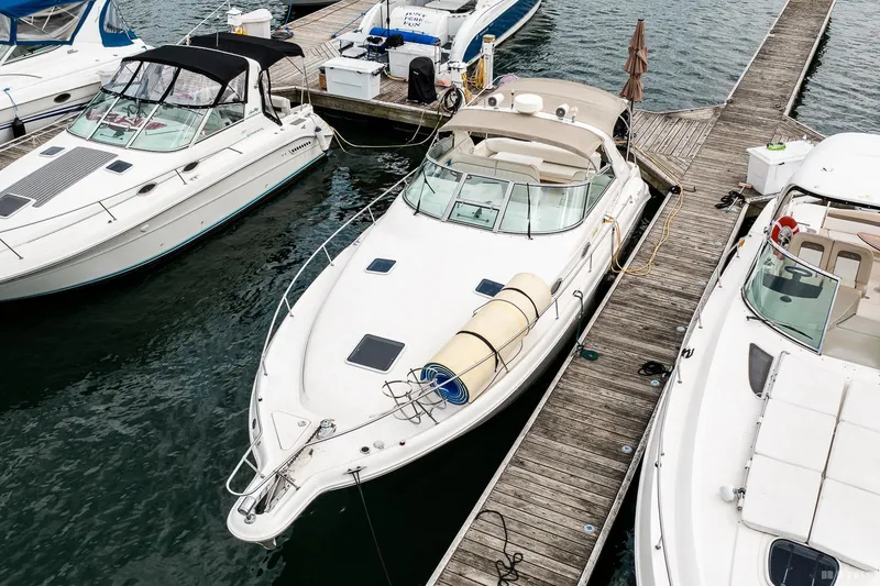 Slide: The Image of 1998 Sea Ray 330 Sundancer docked at marina, surrounded by other boats. - 2