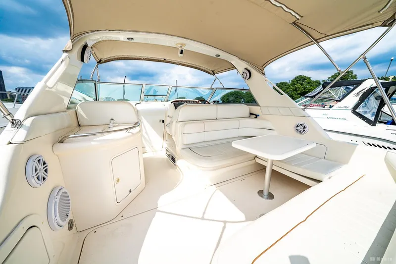 Slide: The Image of 1998 Sea Ray 330 Sundancer interior with white seating and table under canopy. - 20