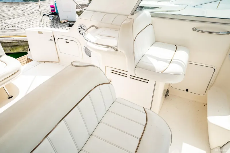Slide: The Image of 1998 Sea Ray 330 Sundancer interior with white cushioned seating and storage compartments. - 25