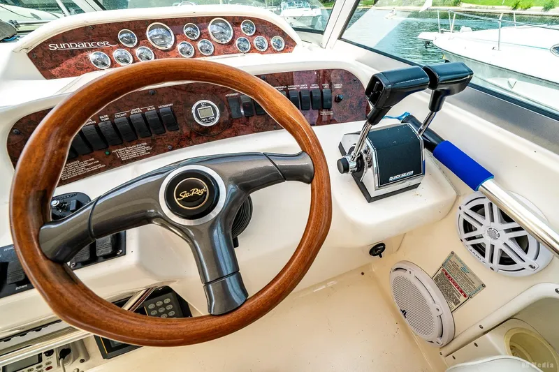 Slide: The Image of 1998 Sea Ray 330 Sundancer helm with wood steering wheel and control panel. - 29