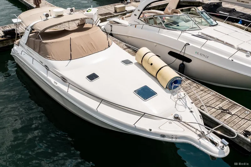 Slide: The Image of 1998 Sea Ray 330 Sundancer yacht docked at marina, featuring sleek design and beige canopy. - 4