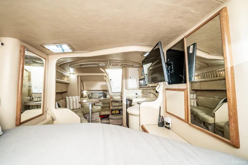 Slide: The Image of 1998 Sea Ray 330 Sundancer cabin interior with seating, mirrors, and TV. - 45