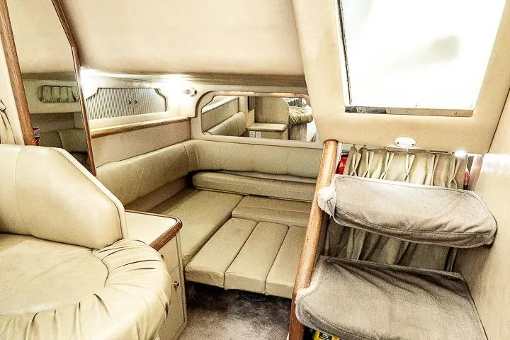 Slide: The Image of 1998 Sea Ray 330 Sundancer cabin interior with beige seating and soft lighting. - 47