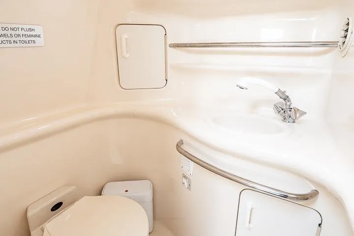 Slide: The Image of 1998 Sea Ray 330 Sundancer bathroom with toilet, sink, and storage compartments. - 49