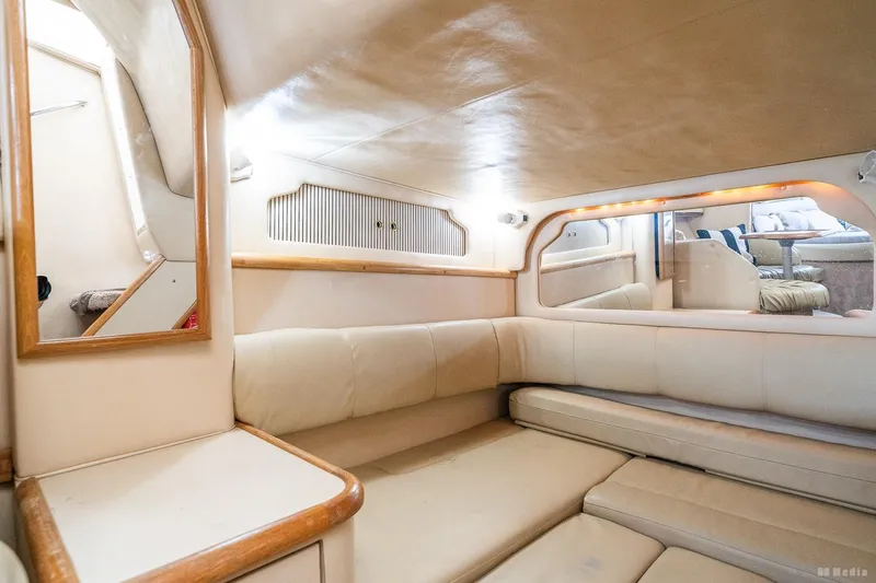 Slide: The Image of Interior of 1998 Sea Ray 330 Sundancer yacht with beige seating and wood accents. - 50