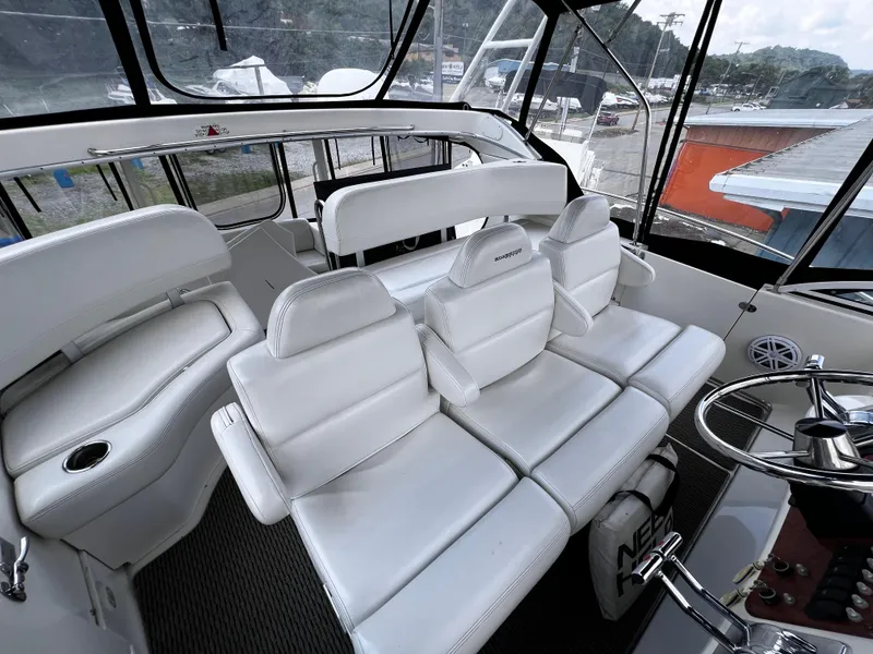 Slide: The Image of 2004 Silverton 39 Motor Yacht interior with white seating and helm station. - 10