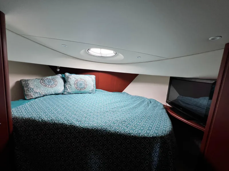 Slide: The Image of Cozy bedroom in 2004 Silverton 39 Motor Yacht with patterned bedding and porthole window. - 17