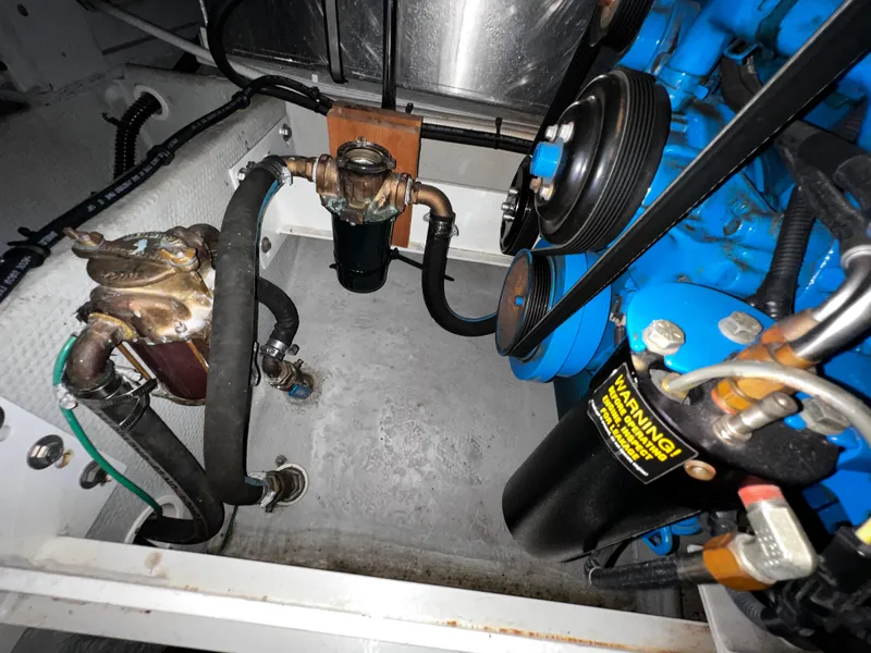 Slide: The Image of Engine compartment of a 2004 Silverton 39 Motor Yacht, showcasing mechanical components and hoses. - 28