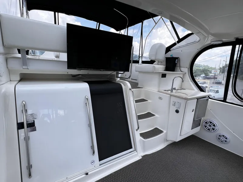 Slide: The Image of 2004 Silverton 39 Motor Yacht interior with TV, stairs, and kitchenette. - 3