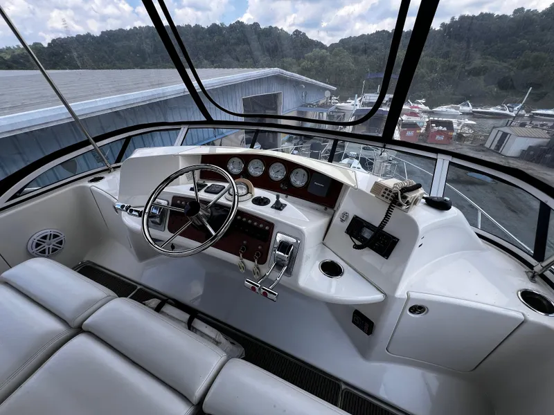 Slide: The Image of 2004 Silverton 39 Motor Yacht helm with steering wheel, gauges, and controls. - 9