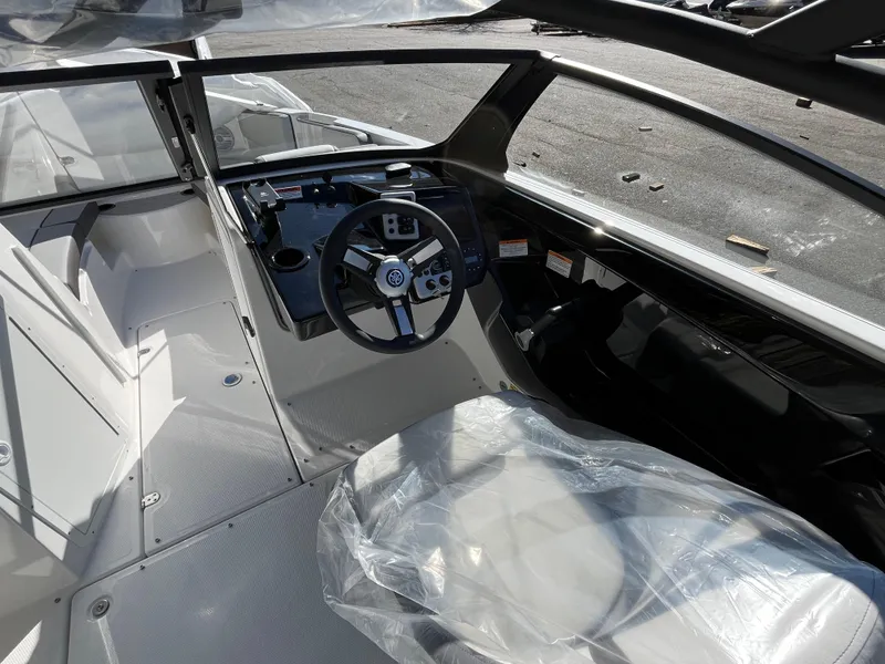 Slide: The Image of 2025 Yamaha Boats AR220 interior with steering wheel and covered seats. - 11
