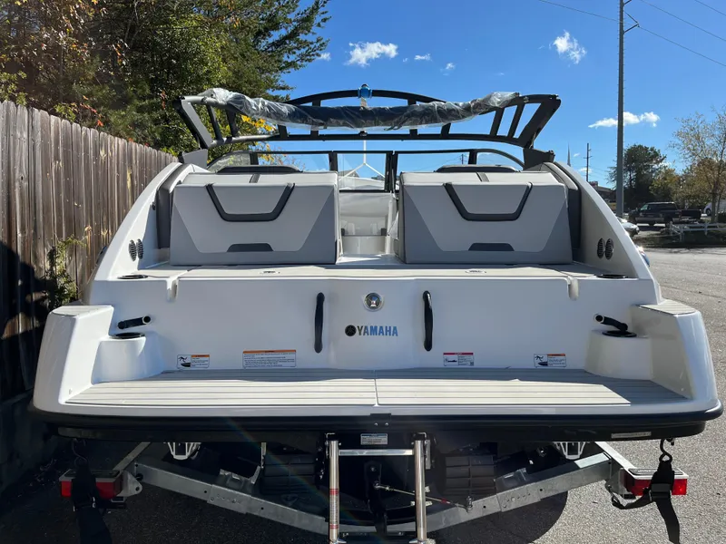 Slide: The Image of 2025 Yamaha Boats AR220, rear view, parked on trailer, sunny day. - 12