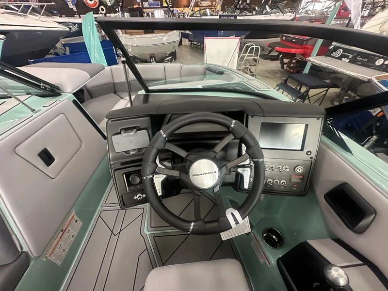 Slide: The Image of 2025 Moomba Max boat interior with steering wheel and dashboard controls. - 23