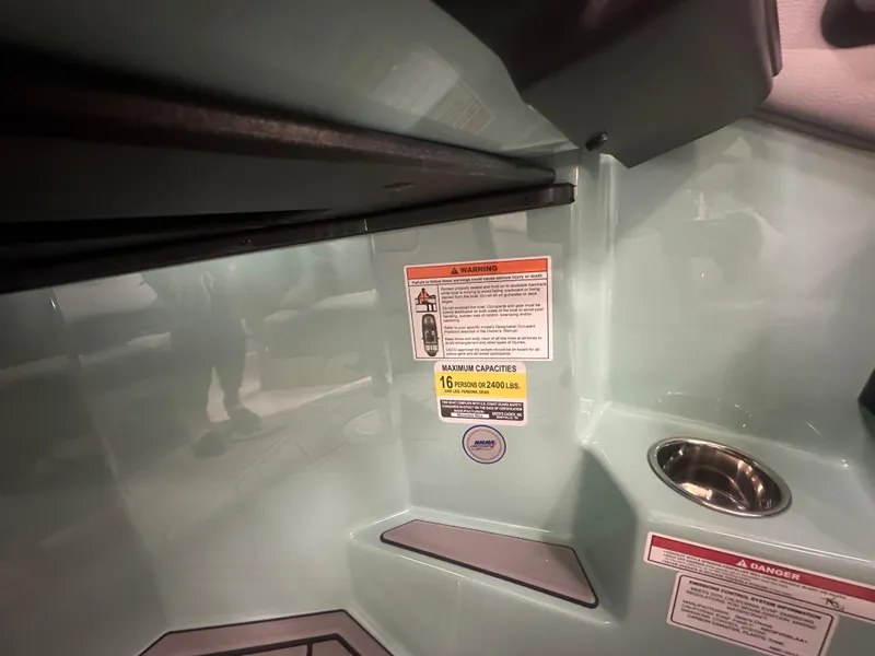 Slide: The Image of 2025 Moomba Max interior with safety warnings and cup holder. - 26