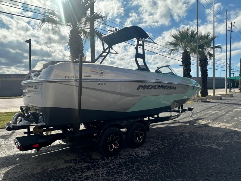 Slide: The Image of 2025 Moomba Max boat on trailer, parked under palm trees, sunny day. - 4