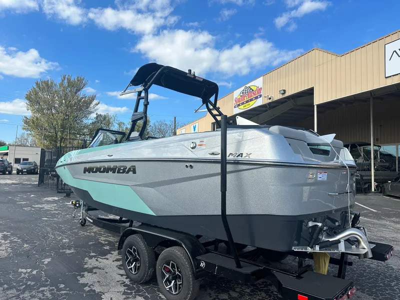 Slide: The Image of 2025 Moomba Max boat on trailer, parked outdoors under blue sky. - 5