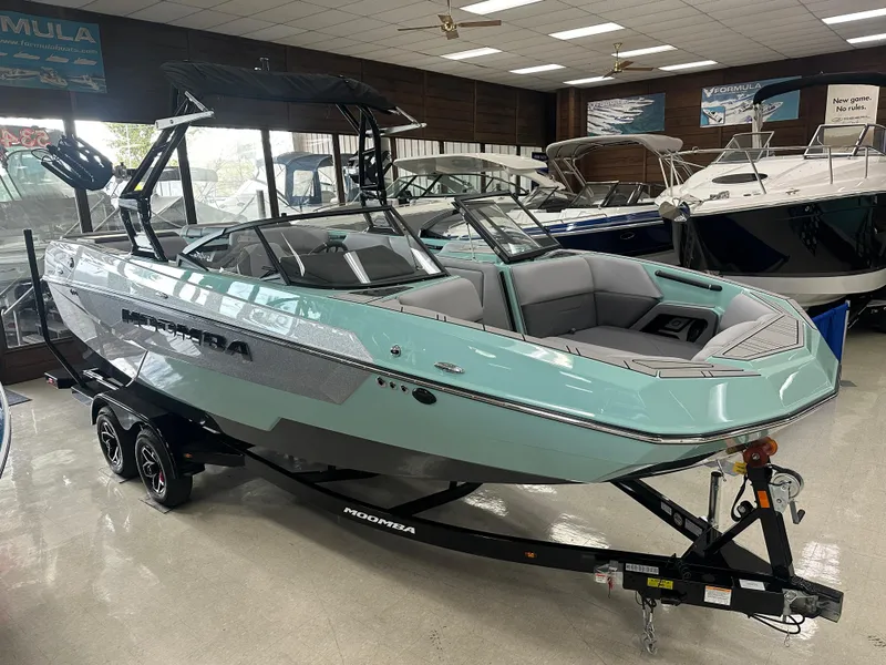 Slide: The Image of 2025 Moomba Max boat in showroom, mint green exterior, on trailer. - 7
