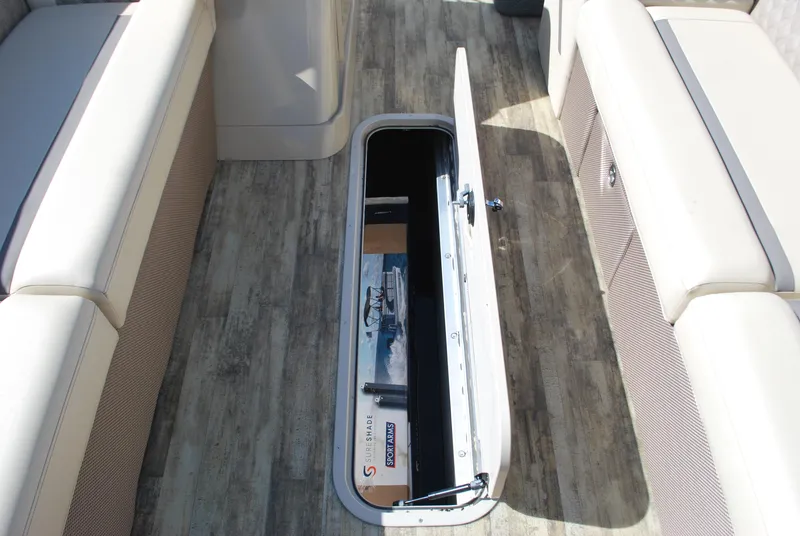 Slide: The Image of 2024 Crest Classic Platinum 240 SLC boat interior with open storage compartment. - 10