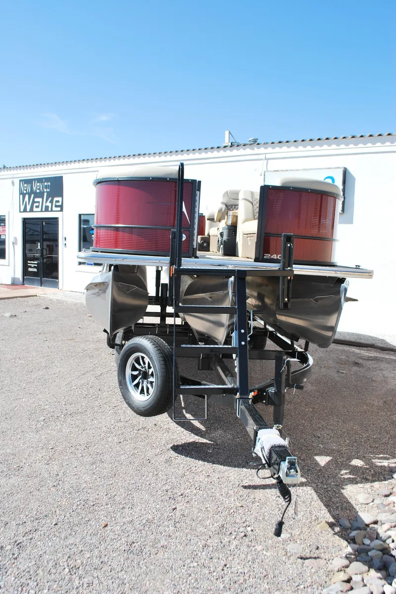 Slide: The Image of 2024 Crest Classic Platinum 240 SLC pontoon boat on trailer, outside dealership. - 2