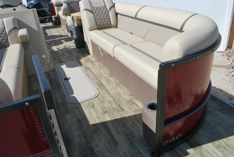 Slide: The Image of 2024 Crest Classic Platinum 240 SLC pontoon boat interior with beige seating and wood-style flooring. - 3