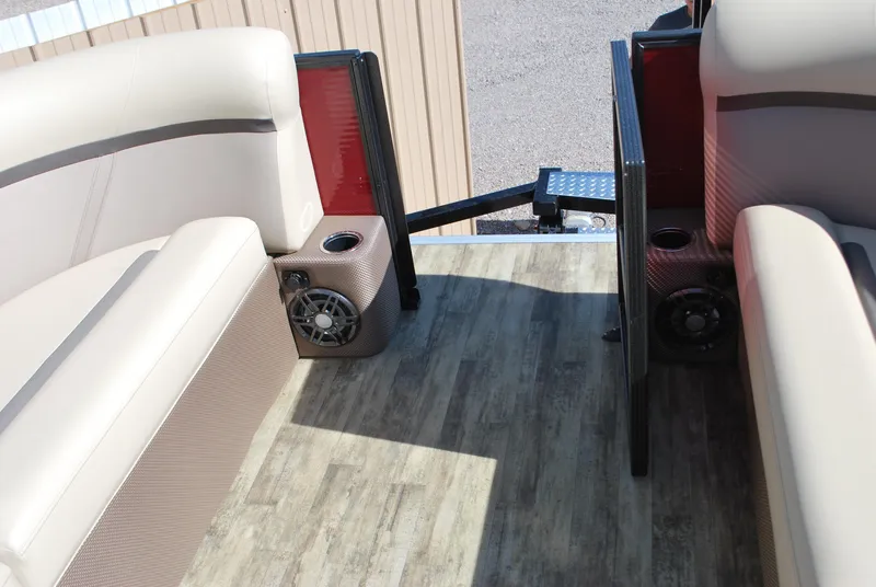 Slide: The Image of 2024 Crest Classic Platinum 240 SLC boat interior with beige seating and wood-style flooring. - 4