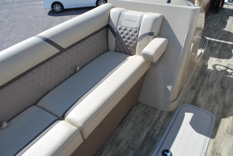 Slide: The Image of 2024 Crest Classic Platinum 240 SLC boat interior with beige seating and modern design. - 7