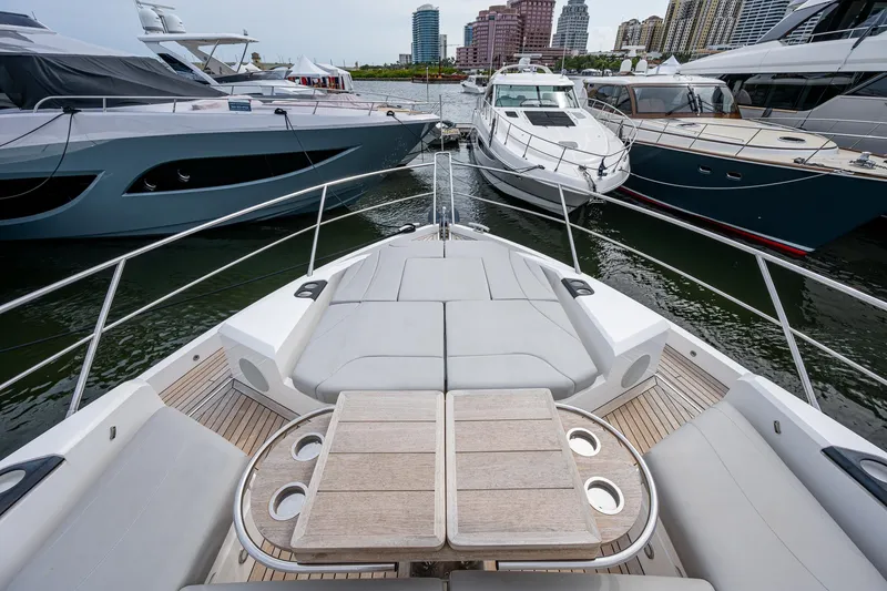 Slide: The Image of Sunseeker Manhattan 68 yacht, 2022 model, docked among other luxury boats in a marina. - 13