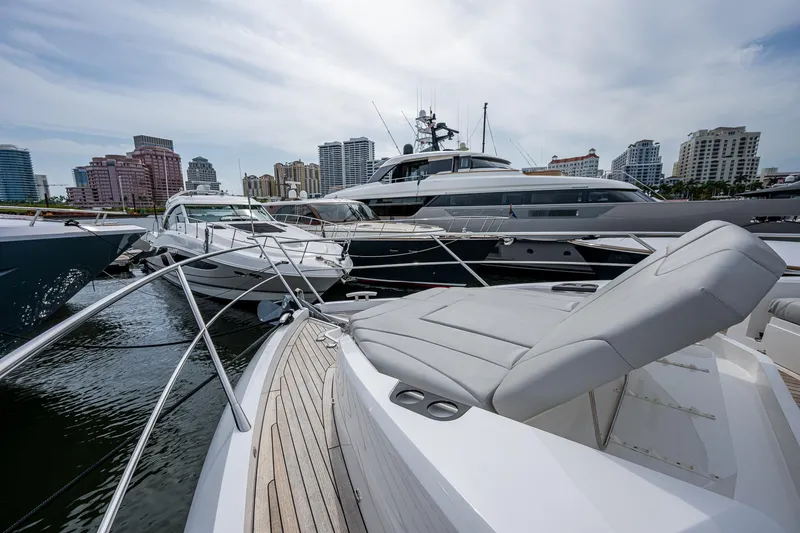 Slide: The Image of Sunseeker Manhattan 68 yacht, 2022 model, docked in a marina with city skyline backdrop. - 17