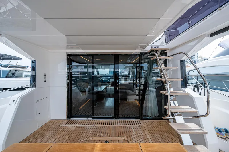 Slide: The Image of 2022 Sunseeker Manhattan 68 yacht interior with wooden deck and modern glass doors. - 25