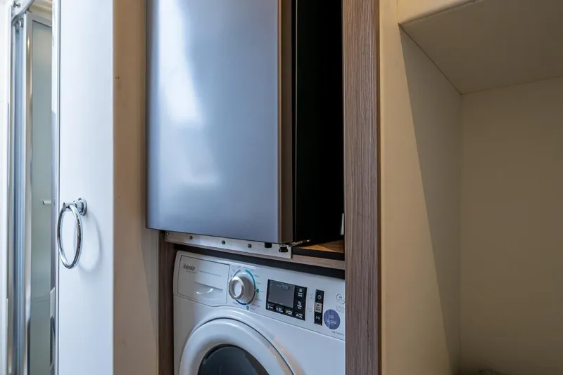 Slide: The Image of Laundry area with modern washer and dryer on Sunseeker Manhattan 68 yacht, 2022 model. - 37
