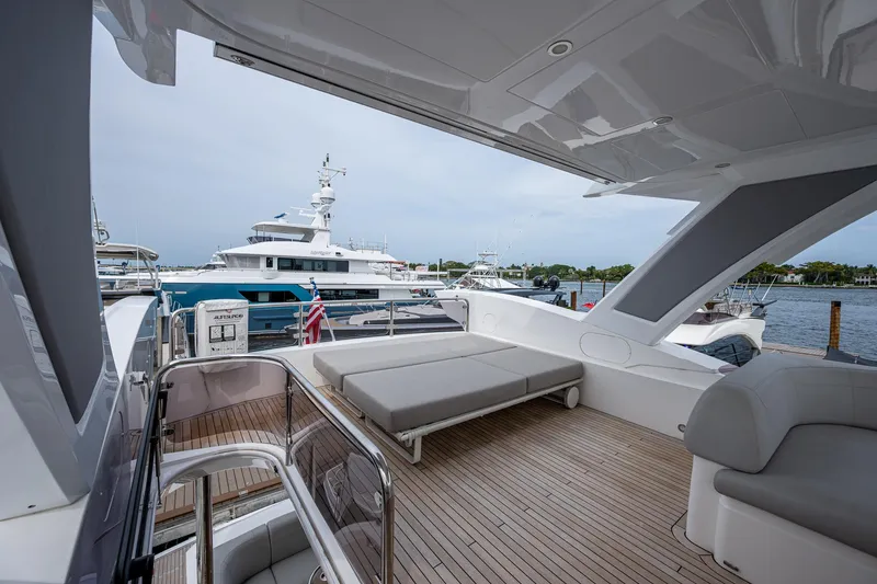 Slide: The Image of Luxurious 2022 Sunseeker Manhattan 68 yacht deck with seating and scenic marina view. - 49