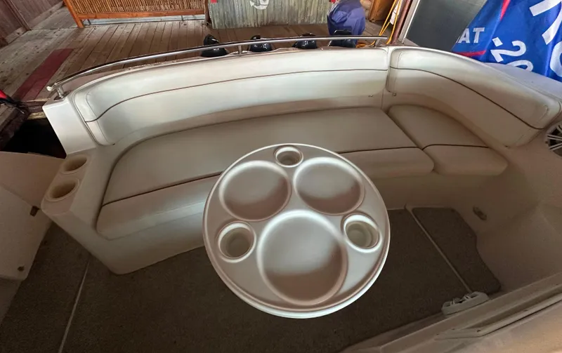 Slide: The Image of 2003 Rinker Fiesta Vee 312 boat interior with beige seating and round table. - 10