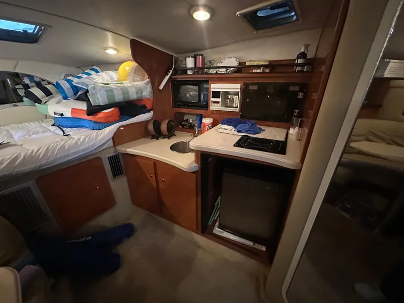 Slide: The Image of Interior of 2003 Rinker Fiesta Vee 312 boat with kitchenette and cozy sleeping area. - 19