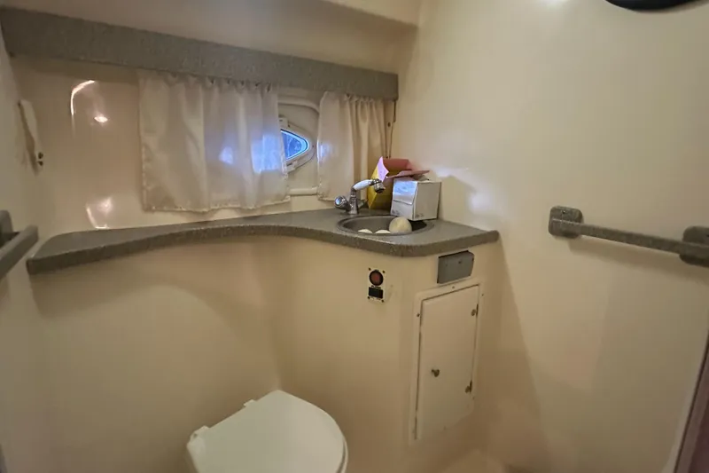 Slide: The Image of 2003 Rinker Fiesta Vee 312 boat bathroom with sink, toilet, and window. - 26