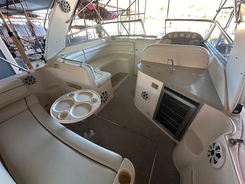 Slide: The Image of 2003 Rinker Fiesta Vee 312 boat interior with seating, table, and kitchenette. - 3