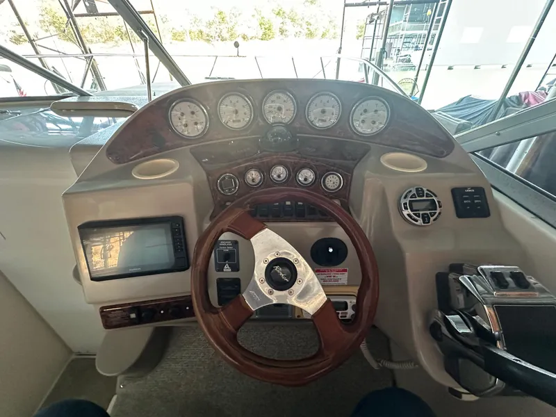 Slide: The Image of 2003 Rinker Fiesta Vee 312 helm with gauges, steering wheel, and navigation system. - 6