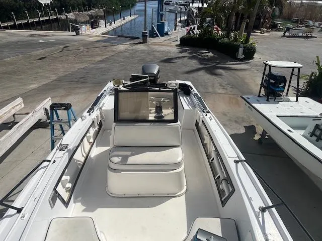 Slide: The Image of 1985 Mako 21B boat at dock, featuring spacious seating and open deck design. - 1