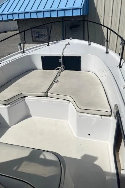 Slide: The Image of 1985 Mako 21B boat interior with cushioned seating and railing. - 6
