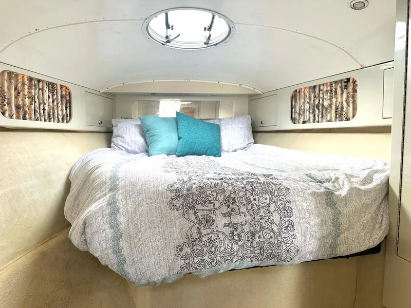 Slide: The Image of Cozy cabin interior of 1999 Wellcraft 45 Excalibur with bed and decorative pillows. - 10