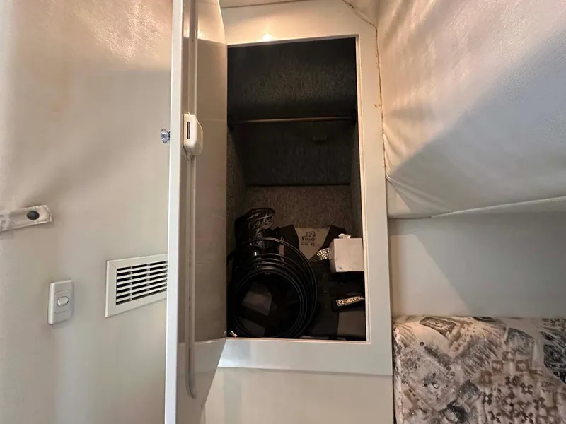 Slide: The Image of Open storage cabinet inside 1999 Wellcraft 45 Excalibur boat, containing cables and equipment. - 15