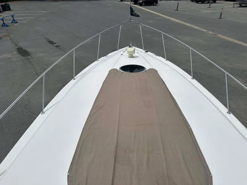 Slide: The Image of 1999 Wellcraft 45 Excalibur boat deck with beige cover in parking lot. - 30