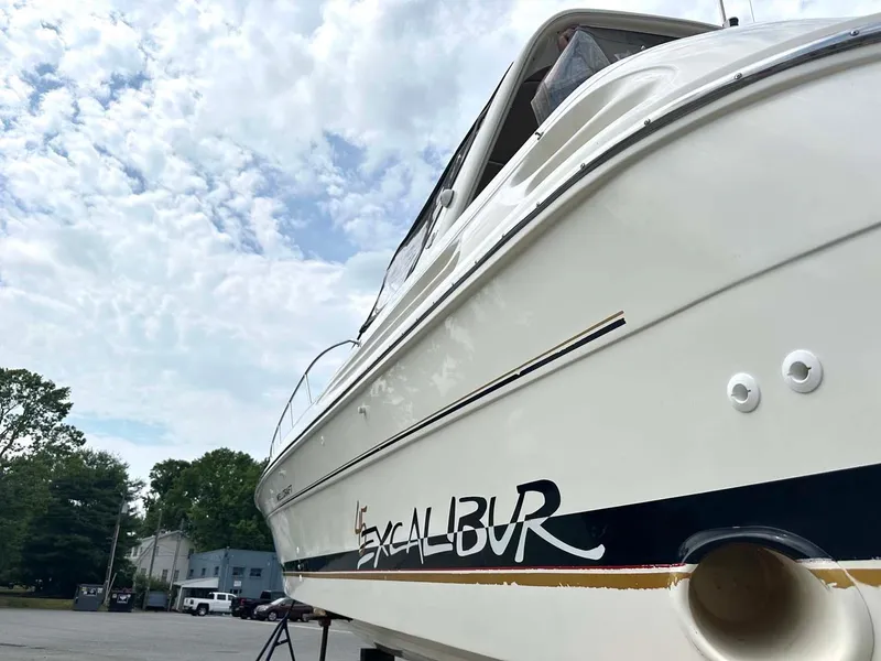 Slide: The Image of 1999 Wellcraft 45 Excalibur boat with sleek design under a cloudy sky. - 35
