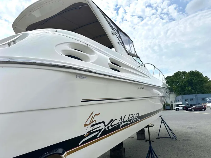 Slide: The Image of 1999 Wellcraft 45 Excalibur boat on stands, side view under cloudy sky. - 38