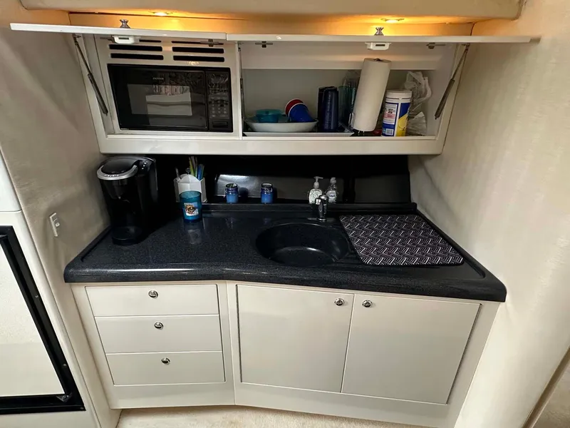 Slide: The Image of Compact kitchenette in 1999 Wellcraft 45 Excalibur boat with sink, microwave, and storage. - 8