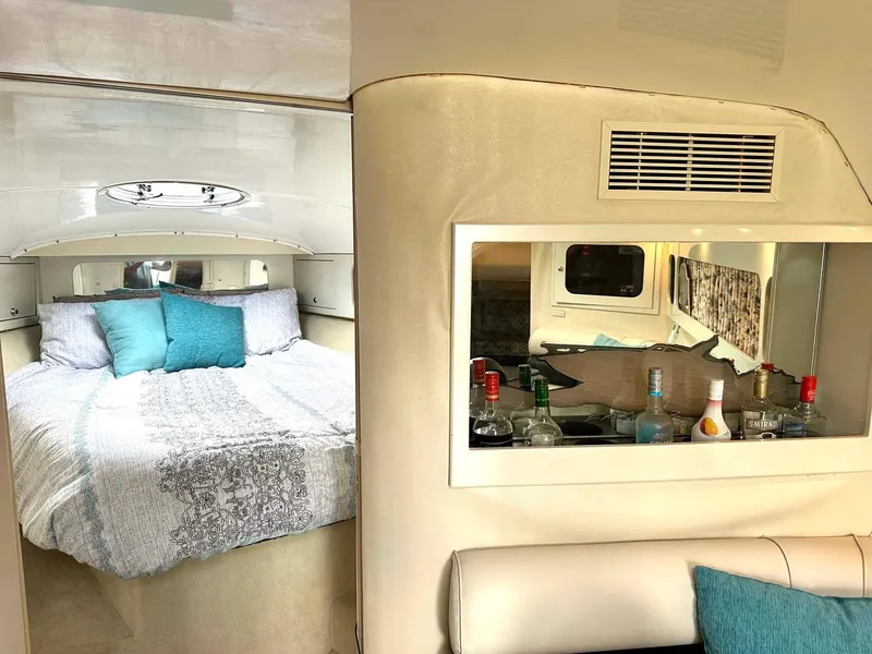 Slide: The Image of Interior of 1999 Wellcraft 45 Excalibur with cozy bed and mini bar setup. - 9