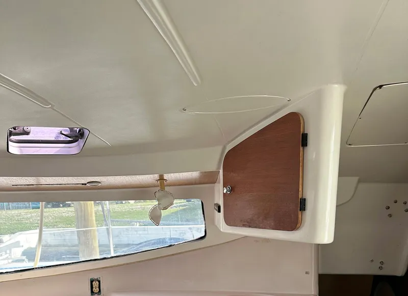 Slide: The Image of Interior of 1998 Fountaine Pajot Athena 38 catamaran, featuring a wooden cabinet and window. - 10