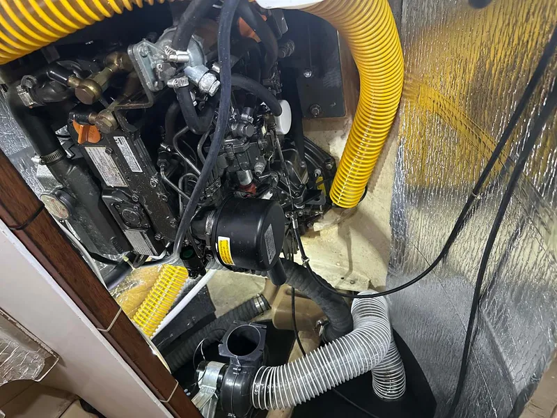 Slide: The Image of Engine compartment of 1998 Fountaine Pajot Athena 38 catamaran with visible hoses and components. - 32