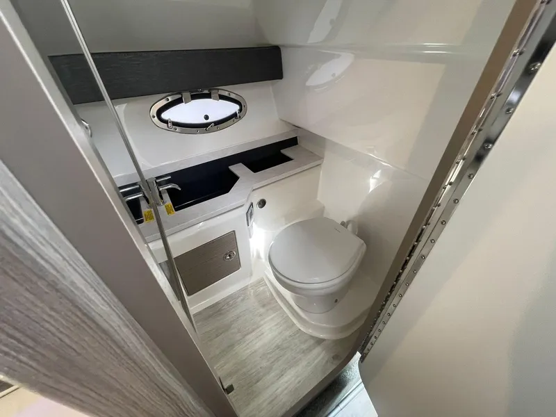 Slide: The Image of 2023 Formula 330 Crossover Bowrider OB bathroom with modern fixtures and porthole window. - 18