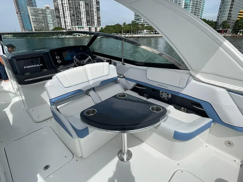 Slide: The Image of 2023 Formula 330 Crossover Bowrider OB interior with seating and table, waterfront view. - 34